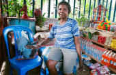 Ibu Nene Seret, head of the Warsambin women's cooperative with her pet Western Crowned Pigeon in the cooperative store at Warsambin, Pulau Waigeo, Raja Ampat