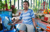 Ibu Nene Seret, head of Warsambin's women's cooperative, with her pet Western Crowned Pigeon in the Dasawisma store